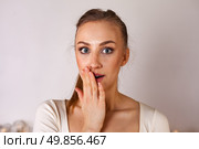 Surprised Young Woman Expressing Diverse Emotions in a Cozy Studio Setting. Стоковое фото, фотограф Aleksandr Golubev / Фотобанк Лори