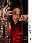 Lady in Red Captures a Moment Behind Glimmering Beaded Curtains Indoors. Стоковое фото, фотограф Aleksandr Golubev / Фотобанк Лори
