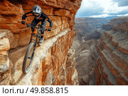 A stunning extreme mountain bike photo of a cyclist in full protective gear riding along a narrow rocky path above a deep canyon. He balances literally inches from the edge, demonstrating a high level of skill, courage and control. The dramatic canyon scenery with steep cliffs and a winding river below highlights the scale and danger of the route. The striking contrasts between the orange rocks, the dark uniform of the rider and the dramatic sky make the image dynamic and visually intense.Perfect for themes of sports, adventure, extreme, freedom, willpower and overcoming fears. Стоковое AI-изображение, AI-художник Анна Кривицкая / Фотобанк Лори
