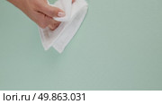 A woman's hand wipes water drops from a green rug with a white cloth. Стоковое видео, видеограф Катерина Белякина / Фотобанк Лори