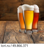 Different beer in glasses on wooden background. Стоковое фото, агентство Ingram Publishing / Фотобанк Лори