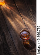 Cognac in glass on the wooden surface. Cognac in glass on the wood. Стоковое фото, агентство Ingram Publishing / Фотобанк Лори