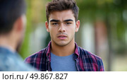 Serious conversation: Portrait of a young man in a flannel shirt looking intently at another person. Стоковое AI-изображение, AI-художник Данила Большаков / Фотобанк Лори