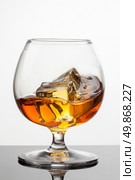 Splash of whiskey with ice in glass isolated on white background. Raw image, no postproduction. Стоковое фото, агентство Ingram Publishing / Фотобанк Лори