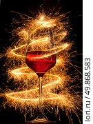 Wine in glass with burning sparklers on black background. Стоковое фото, агентство Ingram Publishing / Фотобанк Лори