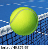 Tennis sport concept with a ball flying over the court net or netting as a leisure fitness and exercise symbol and health care icon for recreational exercising and living a fit lifestyle. Стоковое фото, агентство Ingram Publishing / Фотобанк Лори