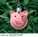 Christmas business concept with a holiday tree ornament decoration shaped as a piggy bank over a green evergreen as a financial symbol of managing gift spending money during the winter festive season. Стоковое фото, агентство Ingram Publishing / Фотобанк Лори