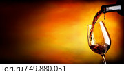 Wine pouring in wineglass  on an orange background. Стоковое фото, агентство Ingram Publishing / Фотобанк Лори