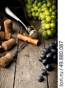 Wine with grape and corks on wooden table. Стоковое фото, агентство Ingram Publishing / Фотобанк Лори