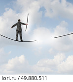 Risk management solutions business metaphor as a businessman walking on a tight rope or highwire holding the missing piece of rope to complete the journey ahead as a business leadership concept of adapting to change for success. Стоковое фото, агентство Ingram Publishing / Фотобанк Лори