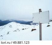A barren signpost labeled Snow Mountain North stands against a backdrop of soft, white snow and rolling hills, surrounded by a tranquil winter atmosphere and overcast skies Generative AI. Стоковое AI-изображение, AI-художник Юлия Петровская / Фотобанк Лори