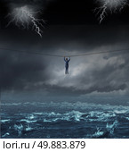 Surviving the storm business concept with a businessman hanging on to a tightrope crossing over dangerous water as a concept and metaphor for conquering adversity and overcoming challenges. Стоковое фото, агентство Ingram Publishing / Фотобанк Лори