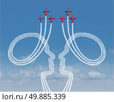 Teamwork management concept as a group of acrobatic jet airplanes creating smoke shaped as two people working together in partnership for a successful coordinated organization for success. Стоковое фото, агентство Ingram Publishing / Фотобанк Лори