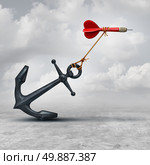 Challenges in business as a dart being slowed down by a heavy anchor as an adversity metaphor and symbol or overcoming a handicap to achieve your goal to reach the target. Стоковое фото, агентство Ingram Publishing / Фотобанк Лори