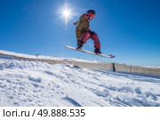 Snowboarder executing a radical jump against blue sky. Стоковое фото, агентство Ingram Publishing / Фотобанк Лори
