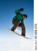 Snowboarder executing a radical jump against blue sky. Стоковое фото, агентство Ingram Publishing / Фотобанк Лори