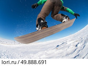 Snowboarder executing a radical jump against blue sky. Стоковое фото, агентство Ingram Publishing / Фотобанк Лори