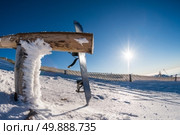 Snowboard leaning on a wood rail on a winter snow covered mountainside and sun shine in blue sky. Стоковое фото, агентство Ingram Publishing / Фотобанк Лори