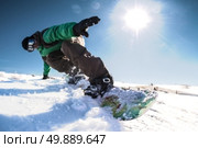Snowboard freerider in the mountains against sun shine in blue sky. Стоковое фото, агентство Ingram Publishing / Фотобанк Лори