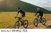 Joyful cyclists adventuring through scenic mountain path at sunset. Стоковое AI-видео, аниматор Владимир Федоров / Фотобанк Лори