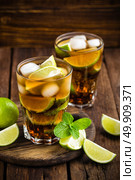 Cuba Libre cocktail with cola, lime and ice in glass, cold longdrink. Стоковое фото, агентство Ingram Publishing / Фотобанк Лори