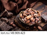 Cocoa beans and chocolate on wooden background. Стоковое фото, агентство Ingram Publishing / Фотобанк Лори