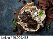 Chocolate brownie cake, dessert with nuts on dark background, directly above, flat lay. Стоковое фото, агентство Ingram Publishing / Фотобанк Лори