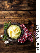 Mashed potatoes, boiled puree in cast iron pot on dark wooden rustic background, top view. Стоковое фото, агентство Ingram Publishing / Фотобанк Лори