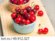 Red ripe cherries in ceramic bowls on kitchen countertop. Стоковое фото, агентство Ingram Publishing / Фотобанк Лори