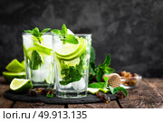 Refreshing mint cocktail mojito with rum and lime, cold drink or beverage with ice on black background. Стоковое фото, агентство Ingram Publishing / Фотобанк Лори
