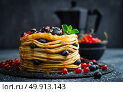Pancakes with fresh berries and maple syrup on dark background, closeup. Стоковое фото, агентство Ingram Publishing / Фотобанк Лори