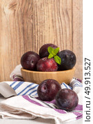 Delicious red plums in a wooden bowl on kitchen countertop. Стоковое фото, агентство Ingram Publishing / Фотобанк Лори