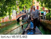 Handsome gondolier during gondola ride on the street of Venice, Italy. Gondolier in Venice. Стоковое фото, агентство Ingram Publishing / Фотобанк Лори