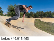 Skateboarder practice on a pump track park on a sunny summer day. Стоковое фото, агентство Ingram Publishing / Фотобанк Лори