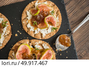 Canape or crostini with multigrain  crispread with cream cheese and fig jam on a slate board. Delicious appetizer ideal as an aperitif. Стоковое фото, агентство Ingram Publishing / Фотобанк Лори