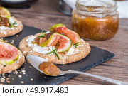 Canape or crostini with multigrain  crispread with cream cheese and fig jam on a slate board. Delicious appetizer ideal as an aperitif. Стоковое фото, агентство Ingram Publishing / Фотобанк Лори