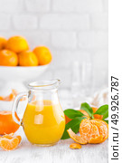 Tangerines, peeled tangerines and tangerine juice in glass. Mandarine juice. Стоковое фото, агентство Ingram Publishing / Фотобанк Лори