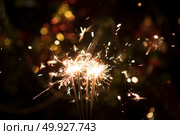 Christmas holding bengal burning sparkler light. Стоковое фото, агентство Ingram Publishing / Фотобанк Лори