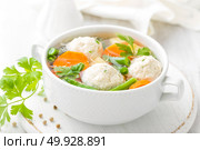 Fresh chicken soup with vegetables and meatballs in a bowl on white background. Top view. Стоковое фото, агентство Ingram Publishing / Фотобанк Лори