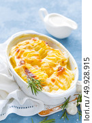 Baked potato gratin with garlic, cream and cheese, traditional french cuisine. White background. Стоковое фото, агентство Ingram Publishing / Фотобанк Лори