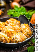Cabbage rolls stewed with meat and vegetables in pan on dark wooden background. Стоковое фото, агентство Ingram Publishing / Фотобанк Лори
