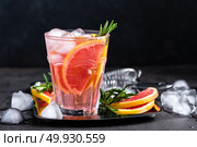 Grapefruit and fresh rosemary gin cocktail with juice, cold summer citrus refreshing drink or beverage with ice. Стоковое фото, агентство Ingram Publishing / Фотобанк Лори