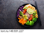 Buddha bowl dish with chicken fillet, brown rice, avocado, pepper, tomato, broccoli, red cabbage, chickpea, fresh lettuce salad, pine nuts and walnuts. Healthy balanced eating. Top view. Стоковое фото, агентство Ingram Publishing / Фотобанк Лори