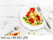 Omelet. Eggs fried. Scrambled eggs with green onion and fresh tomato. Omlette on white plate. Breakfast. Top view. White wooden background. Стоковое фото, агентство Ingram Publishing / Фотобанк Лори