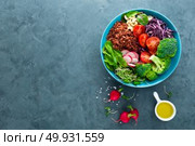 Buddha bowl meal with kale, spinach and chard leaves, brown rice, tomato, broccoli, radish, fresh green sprouts and pine nuts. Healthy balanced nutrition. Vegetarian food. Overhead view. Стоковое фото, агентство Ingram Publishing / Фотобанк Лори