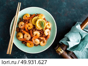 Prawns roasted on grill and boiled brown rice on plate. Grilled shrimps, prawns with rice. Seafood. Asian cuisine. Top view. Dark background. Стоковое фото, агентство Ingram Publishing / Фотобанк Лори
