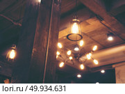 Decorative antique edison style light bulbs against cafe wall background. Стоковое фото, агентство Ingram Publishing / Фотобанк Лори