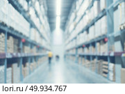 Blurred image of shelf in modern distribution warehouse or storehouse. Defocused background of industrial warehouse interior aisle. Стоковое фото, агентство Ingram Publishing / Фотобанк Лори