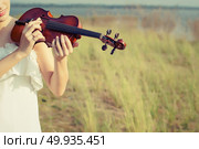 Beautiful Woman standing Playing the violin in the meadow. Стоковое фото, агентство Ingram Publishing / Фотобанк Лори