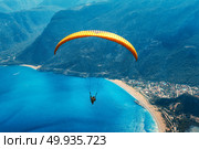 Paragliding in the sky. Paraglider tandem flying over the sea with blue water, beach and mountains in sunrise. Aerial view of paraglider and Blue Lagoon in Oludeniz, Turkey. Extreme sport. Landscape. Paraglider tandem flying over the sea with blue water and mounta. Стоковое фото, агентство Ingram Publishing / Фотобанк Лори